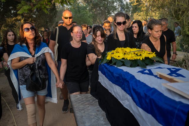 Relatives attend the funeral of Albert Miles, 81, at the Kibbutz Revivim cemetery, south Israel 