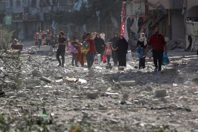 Palestinians leave their homes following Israeli bombardments on Gaza City on Monday