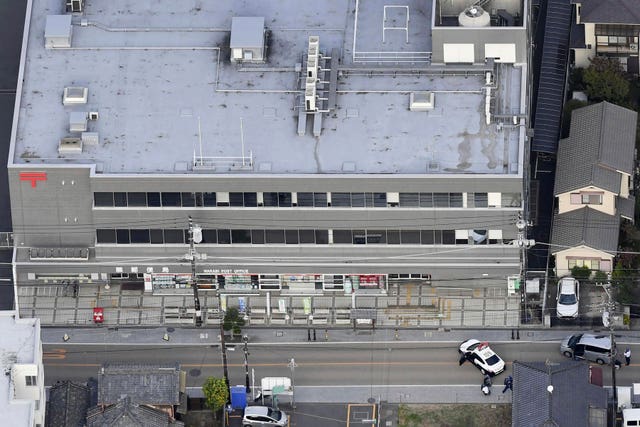 First responders take position outside the post office in Warabi city, Saitama prefecture, north of Tokyo 