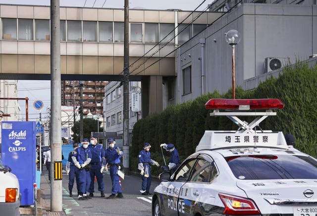 Police officers check an area outside a hospital after a few men were injured in Toda, north of Tokyo