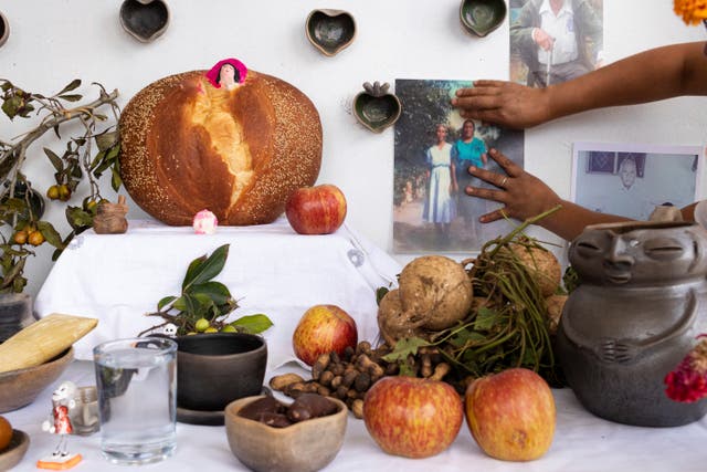 Ana Martínez places a photo on her altar