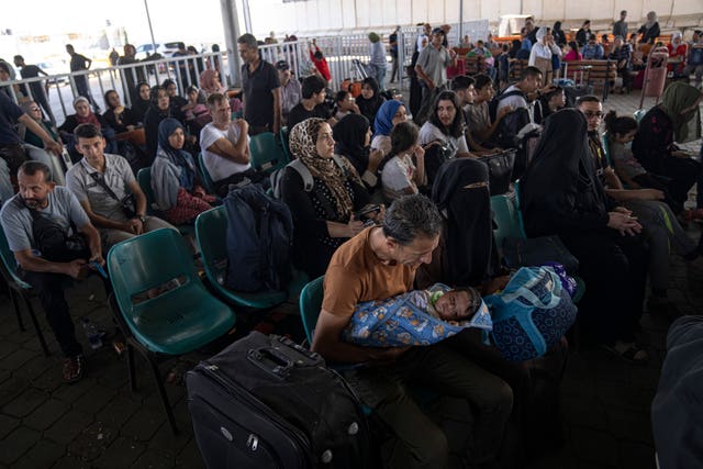 Palestinians wait to cross into Egypt at Rafah on Wednesday