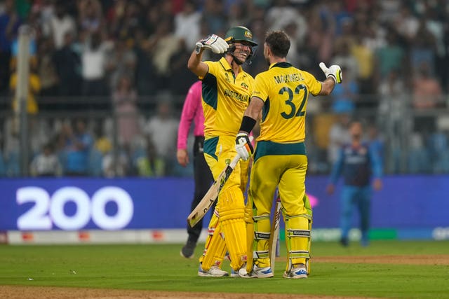 Pat Cummins, left, embraces Glenn Maxwell after victory over Afghanistan