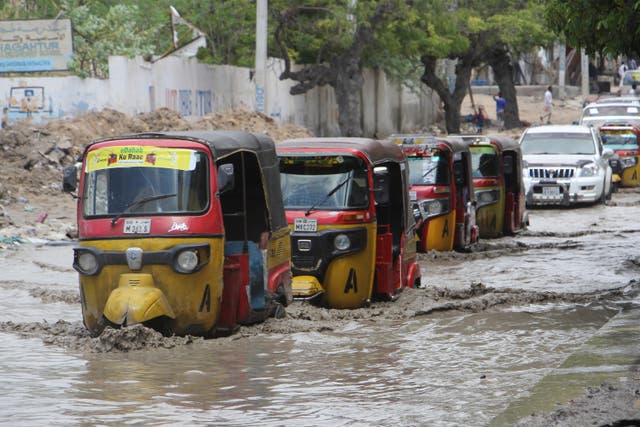 Tuk-tuks pass through a flooded road after heavy rain in Mogadishu, Somalia