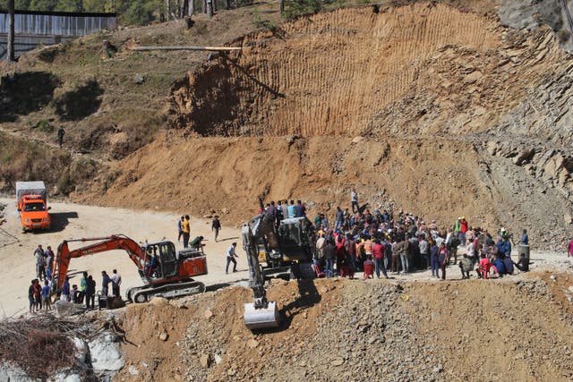 People watch rescue and relief operations at the site of the collapse