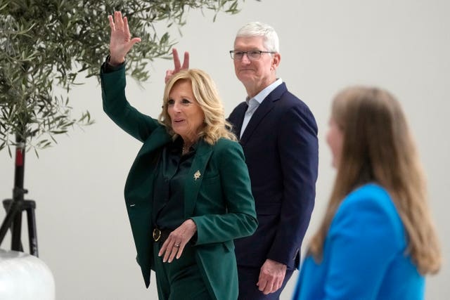 First lady Jill Biden, left, and Apple CEO Tim Cook wave before speaking at a discussion on mental health at a spousal program as part of the APEC Leaders’ Week at the Apple campus in Cupertino, California
