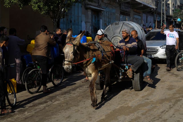 Palestinians transport water during the ongoing Israeli bombardment of the Gaza Strip in Rafah 
