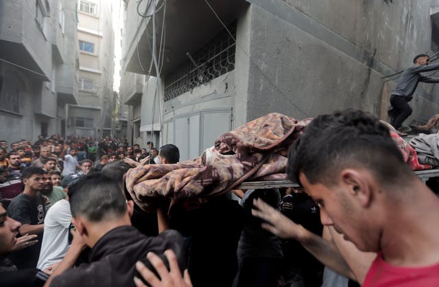 Palestinians evacuate an injured woman found under the rubble of a destroyed house after an Israeli airstrike in Khan Younis refugee camp, southern Gaza Strip, on Saturday 