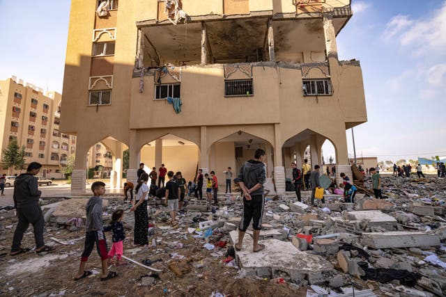 Palestinians look at destruction after an Israeli strike on the Gaza Strip in Khan Younis