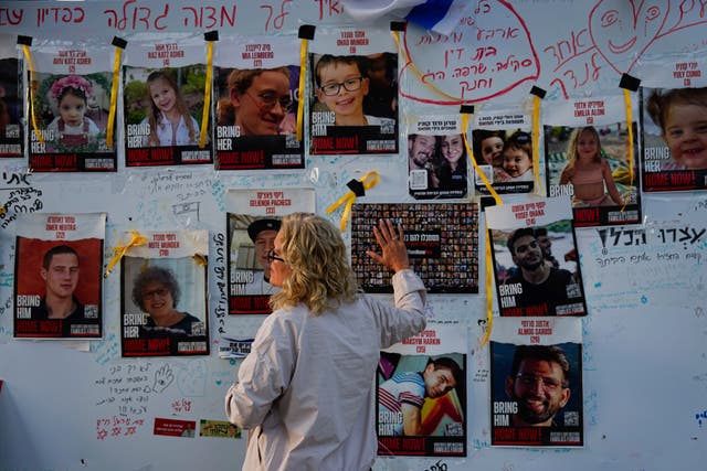 A woman looks at photographs of hostages,