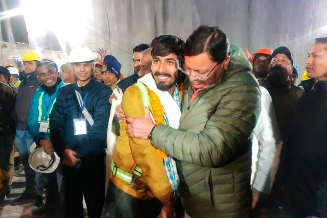 Pushkar Singh Dhami, right, chief minister of the state of Uttarakhand, greets a worker rescued from the site of an under-construction road tunnel that collapsed in Silkyara in the northern Indian state of Uttarakhand, India