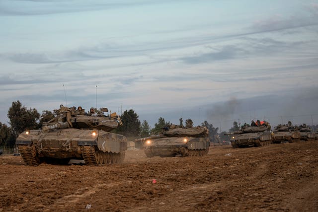 Israeli soldiers move tanks at a staging area near the border with the Gaza Strip, southern Israel 
