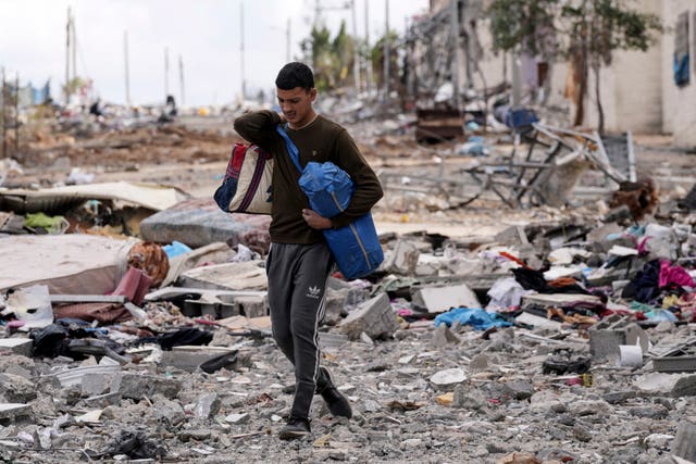 A Palestinian man collects his belongings south-east of the Gaza City