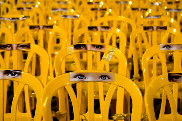 Images of human eyes are placed on empty chairs tied together in an art installation depicting hostages held by Hamas in the Hostages Square at the Museum of Art in Tel Aviv on Wednesday
