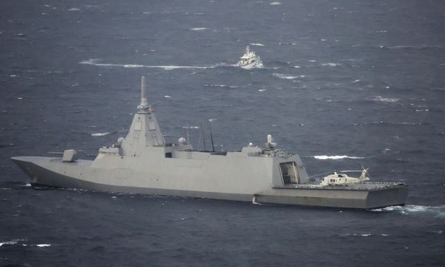 A Japanese coastguard escort ship, bottom, helps in the search and rescue operation
