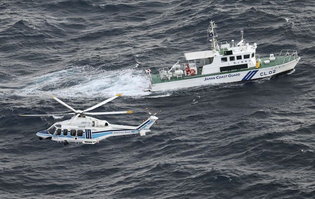 A Japanese coastguard helicopter and patrol vessel conduct a search and rescue operation