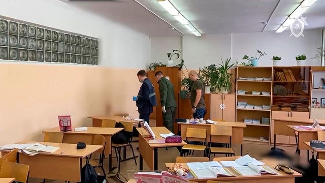 Investigators work at the scene of a shooting in a classroom of a school in Bryansk, Russia