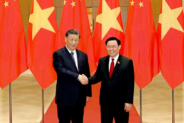 Chinese President Xi Jinping, left, and Vietnamese chairman of the National Assembly Vuong Dinh Hue shake hands as they pose for a photo at the national assembly in Hanoi, Vietnam 