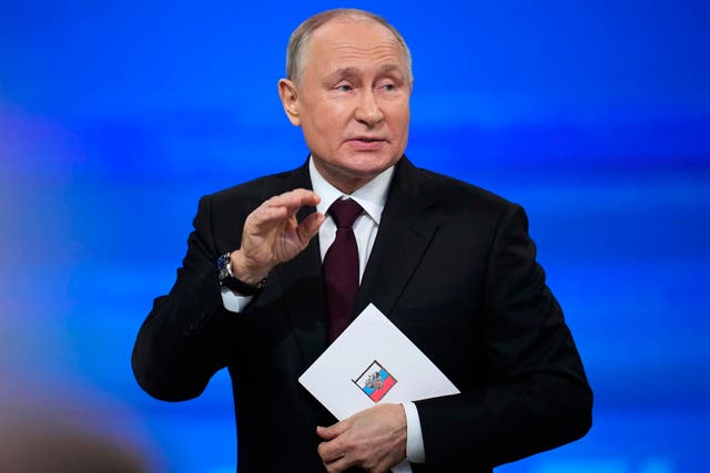 Vladimir Putin leaves the hall after his annual news conference