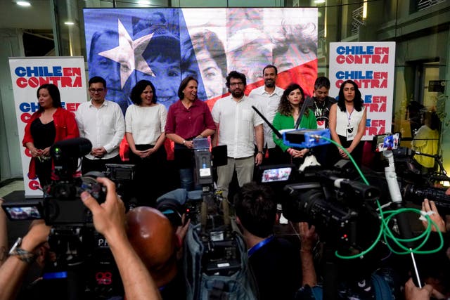 Members of the campaign team against the draft of a new constitution talk to journalists after the polls close