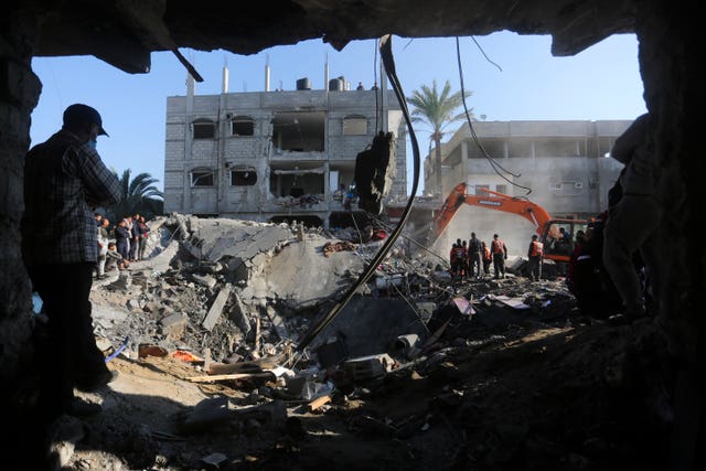 Palestinians search for survivors after the Israeli bombardment of the Gaza Strip outside a morgue in Rafah on Tuesday