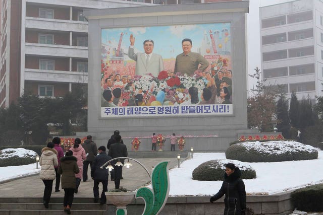 Pyongyang citizens pay respect to mosaics depicting smiling images of their late leaders Kim Il Sung and Kim Jong Il in Pyongyang on Monday