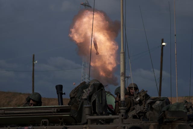 Israeli soldiers fire a mortar shell from southern Israel towards the Gaza Strip