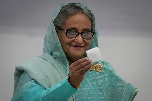 Bangladesh Prime Minister Sheikh Hasina in blue sari holding up a ballot paper