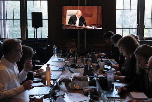 Journalists watch a video screen in a room outside the courtroom during the opening of the hearings at the International Court of Justice in The Hague, Netherlands 