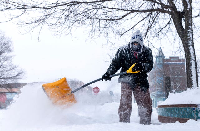 Jose Galeno shovels snow in Omaha, Neb