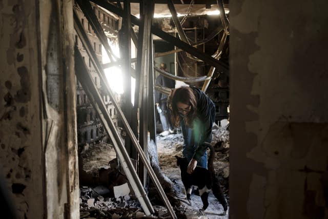 Sharon Alony Cunio is reunited with her cat, Elvis, on Monday in the ruins of her home in Kibbutz Nir Oz from where she was kidnapped with her daughters and husband on October 7 by Hamas militants