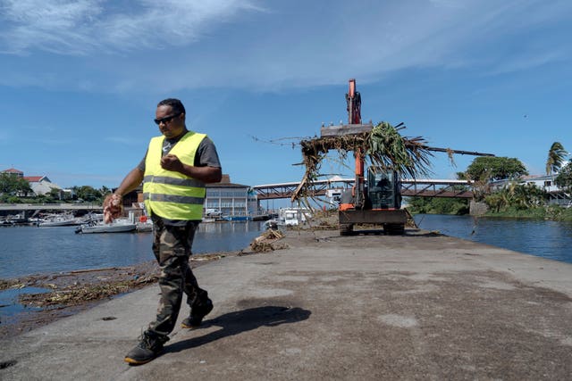 Workers clean up trees and debris on the marina of Saint-Gilles les Bains on the French Indian Ocean island of Reunion