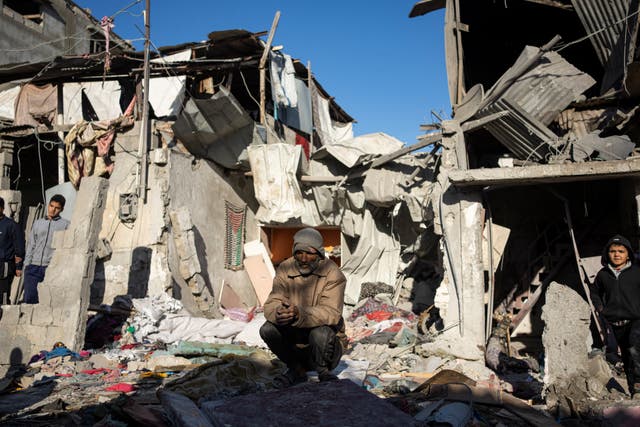 Palestinians look at the destruction after an Israeli strike in Rafah, southern Gaza Strip