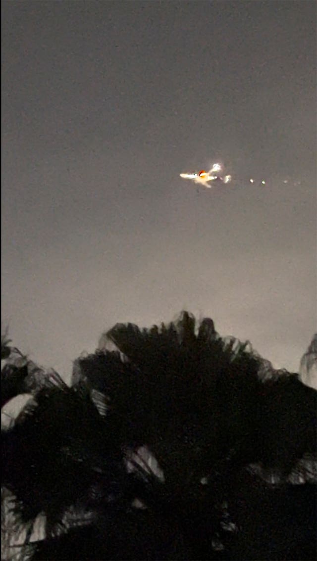 This image taken from video provided by Melanie Adaros shows sparks shooting from a cargo plane before making an emergency landing at Miami International Airport 