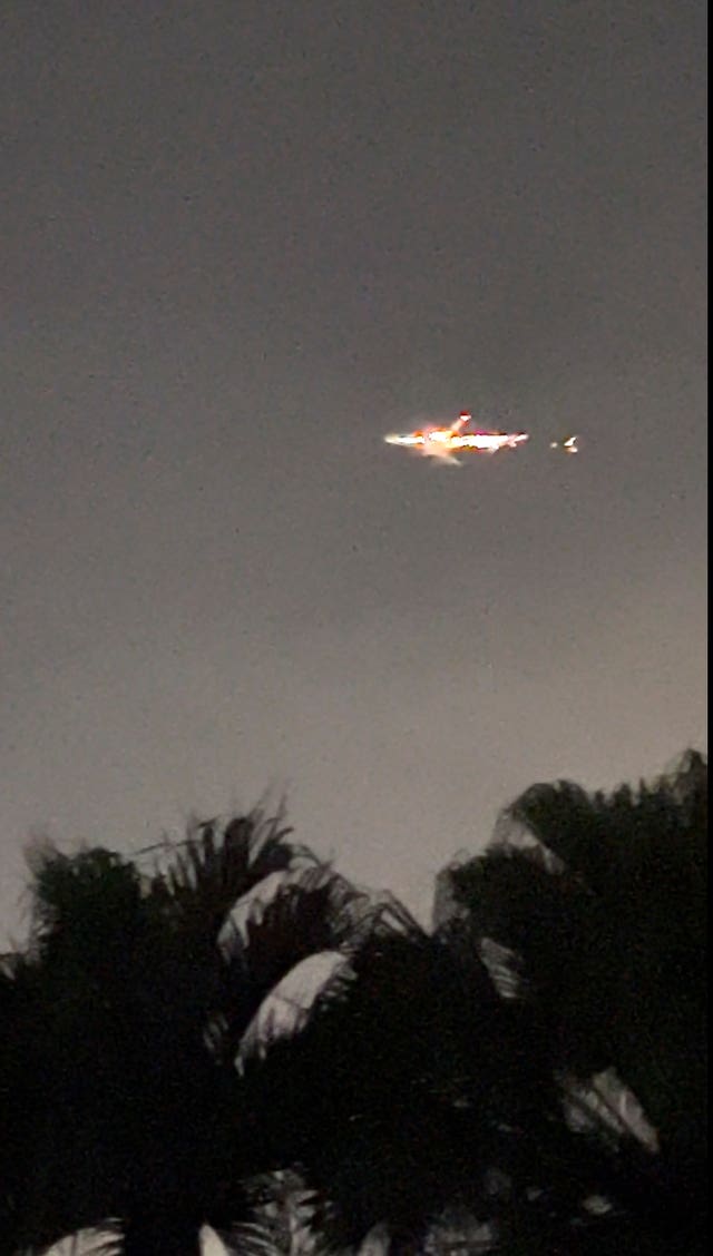 This image taken from video provided by Melanie Adaros shows sparks shooting from a cargo plane before making an emergency landing at Miami International Airport 