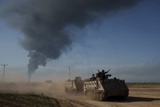 Israeli soldiers move on armoured personnel carriers near the Israeli-Gaza border on Sunday