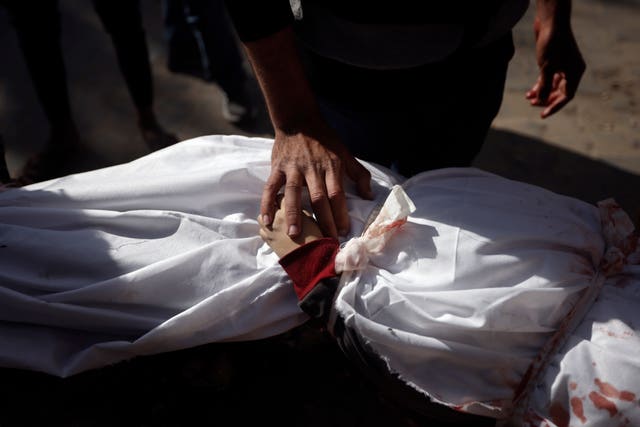 A Palestinian man mourns over the body of a child killed in the Israeli bombardment of the Gaza Strip 