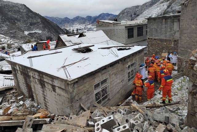 Rescue workers search the site of the landslide in Liangshui 