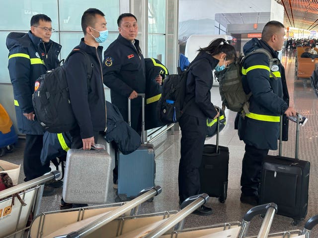 Rescue workers prepare to board a flight to Xinjiang from Beijing Capital International Airport in Beijing on Tuesday 