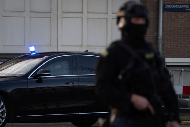 Masked and armed Dutch police guard a transport of some of the suspects who arrived at the high security court building where the trial opens in Amsterdam 
