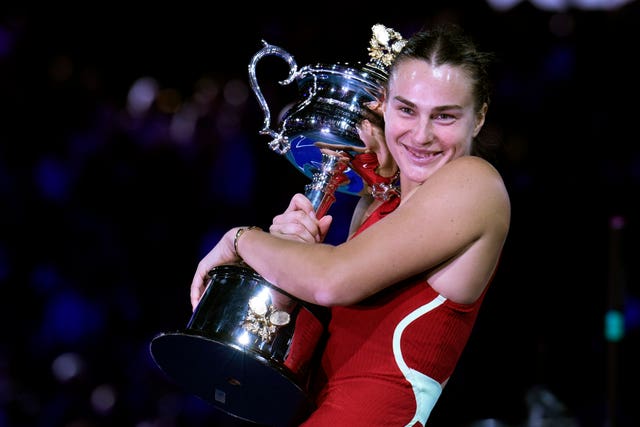 Aryna Sabalenka hugs the trophy