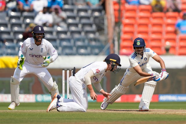 Ollie Pope, centre, takes a catch to remove Shubman Gill, right