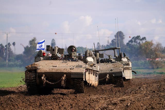Israeli soldiers drive in their armoured vehicles in southern Israel near the border with the Gaza Strip during ongoing ground operations