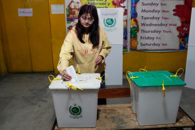 A young woman casts her vote at a polling station during the country’s parliamentary elections, in Lahore, Pakistan