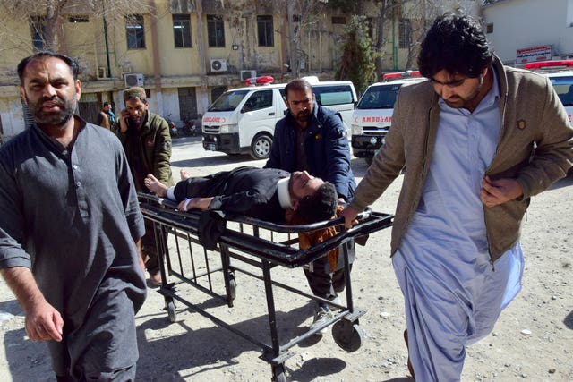 Workers and volunteers transport an injured victim from Pashin district’s bomb blast upon arrival at a hospital in Quetta, Pakistan