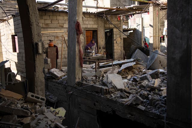 Palestinians look at the destruction after an Israeli strike in Rafah, southern Gaza Strip