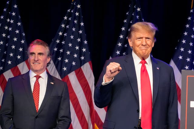 Two men wearing blue jackets and red ties