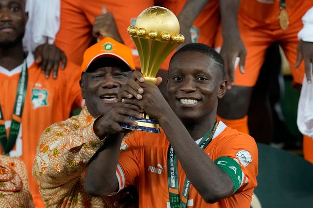 Max Gradel and Ivory Coast president Alassane Ouattara, left, raise the Africa Cup of Nations trophy 