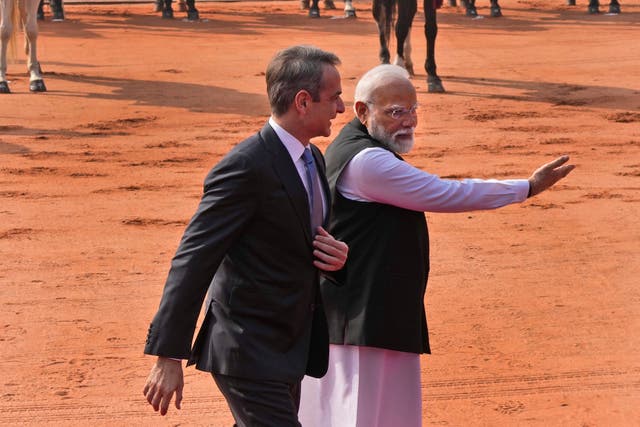 Indian Prime Minister Narendra Modi, right, gestures to Greek Prime Minister Kyriakos Mitsotakis after inspecting a joint military guard of honour during a ceremonial reception at the Indian presidential palace in New Delhi (Manish Swarup/AP)