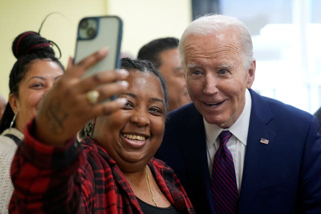 President Joe Biden takes a photo as he visits CJ’s Cafe in Los Angeles
